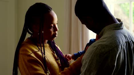 Side-view-of-young-black-parents-holding-their-baby-in-a-comfortable-home-4k