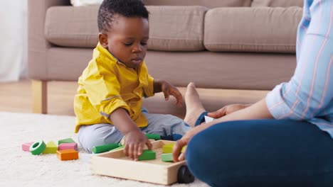 madre-y-el-bebé-jugando-con-bloques-de-juguete-en-casa