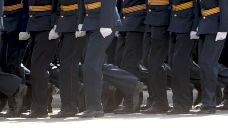 Gente-del-ejército-militar-caminando-en-el-primer-plano-de-botas-en-el-desfile-de-la-plaza-de-la-ciudad.