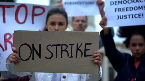 People-waving-banners-on-strike,-protection-of-employee-rights,-work-conditions