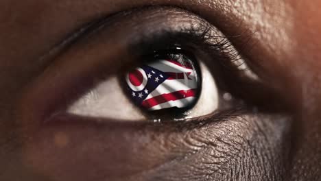Mujer-ojo-negro-en-primer-plano-con-la-bandera-del-estado-de-Ohio-en-iris,-estados-unidos-de-América-con-movimiento-de-viento.-concepto-de-vídeo