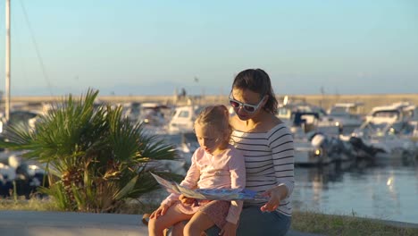 Frau-mit-Tochter-Lesen-Karte-in-der-Nähe-von-Marina