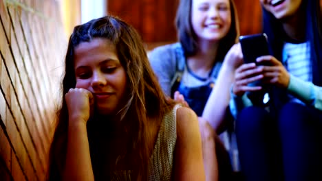 School-friends-bullying-a-sad-girl-in-school-corridor