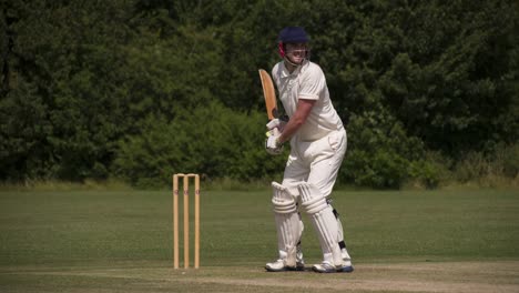 Ein-Cricket-Spieler-mit-der-Wimper-treibt-die-Kugel-in-Zeitlupe.