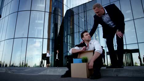 Fired-businessman-sitting-on-street