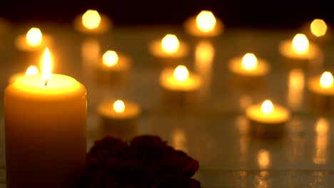 White-candles-lights-with-rose-on-white-desk,-romance-theme