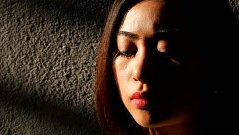 Close-up-on-Sad-depressed-Asian-woman-in-twilight-starts-to-cry