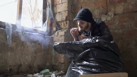 Young-bearded-homeless-smoking-cigarette