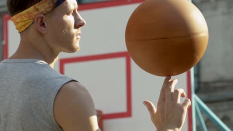 Hübscher-Kerl-Spinnen-Basketball-am-Finger,-Professionalität,-sport