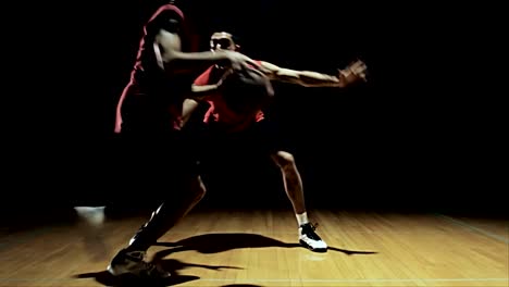 Un-jugador-de-baloncesto-va-en-contra-de-un-defensor-y-gira-alrededor-de-él.