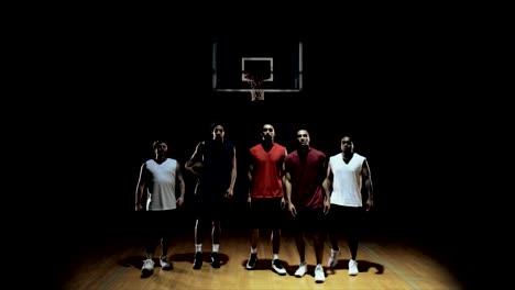 Grupo-de-jugadores-de-baloncesto,-posando-en-la-cancha,-lanzar-bola-y-dejando.