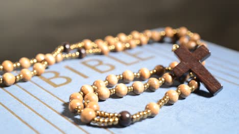 Rotation-of-wooden-rosary-on-the-bible