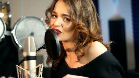 Young-female-singer-recording-album-in-the-professional-studio.