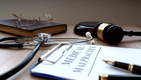 El-juez-utiliza-un-martillo-y-documentos-sobre-mala-praxis-médica.
