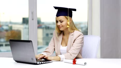 estudiante-en-la-tapa-de-la-licenciatura-con-ordenador-portátil-y-diploma