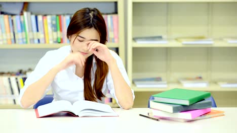 Studie-schwer-in-der-Bibliothek.-Junge-Chinesin-Studium-hart-an-der-Bibliothek.