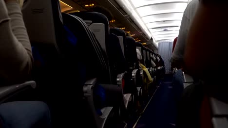 Interior-of-airplane-with-passengers-on-seat-during-flight.-Chairs-on-aisle