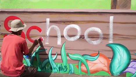 Mural-painter-draws-a-word-School-on-school-wall.-time-lapse