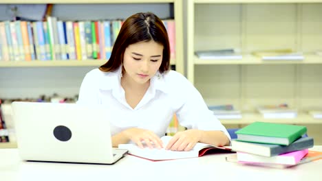 Studie-schwer-in-der-Bibliothek.-Junge-Chinesin-Studium-hart-an-der-Bibliothek.