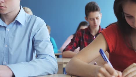 group-of-students-with-notebooks-writing-test-at-school