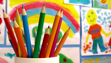 Color-Pencils-In-Classroom-With-Paintings-On-Wall