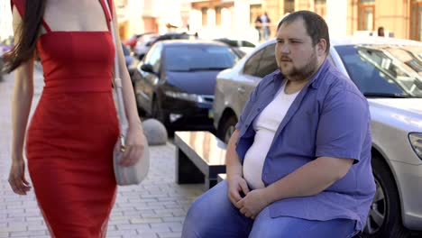 Fat-bachelor-looking-at-pretty-lady-in-red-dress-on-street-and-licking-lips