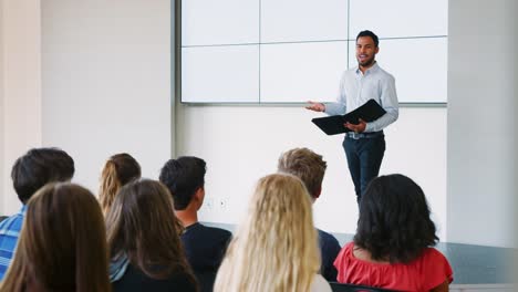 Lehrer-geben-Präsentation-zu-High-School-Klasse-vor-Bildschirm