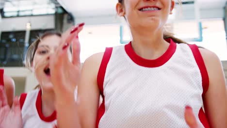 Portrait-Of-Competitive-Female-High-School-Basketball-Team-With-Coach-On-Court