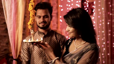 A-happy-husband-and-wife-in-a-house-interior-decorated-with-lights-and-flowers.