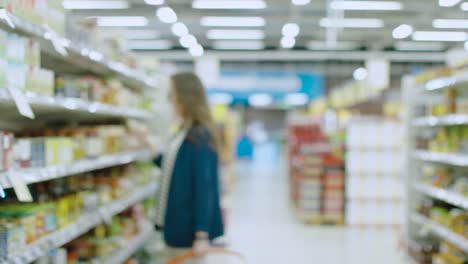 Unscharfe-Aufnahmen-im-Supermarkt-groß-und-hell.-Menschen-und-Kunden-zu-Fuß-durch-die-Gänge-verschiedene-nützliche-Gegenstände-kaufen.