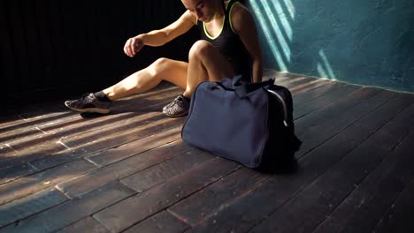 Joven-Closeup-ajuste-las-piernas-de-la-mujer-con-el-bolso-azul-entrar-en-club-de-fitness-y-la-preparación-para-entrenamiento-de-boxeo