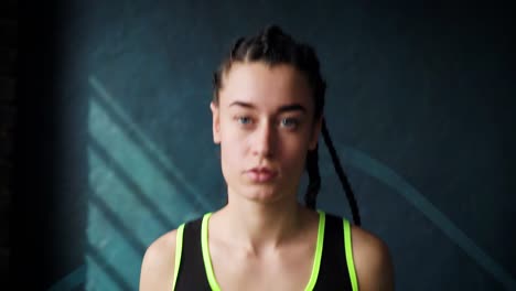 Closeup-young-purposeful-serious-female-boxer-in-wrapped-bandage-fist-hands-jumping-on-skipping-rope