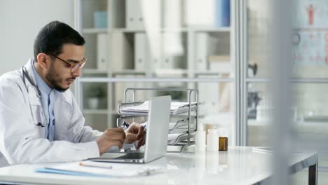 Doctor-Working-with-Laptop-Computer-in-Office