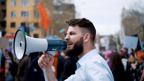 Menschen-in-Stadt-Rallye.-Der-Kerl-schreit-in-den-Lautsprecher.-Die-Masse-auf-der-Straße.