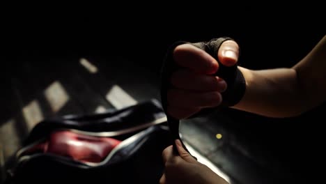 Closeup-fit-woman-wrapping-hands-with-bandage-tape-preparing-for-boxing-training-slow-motion