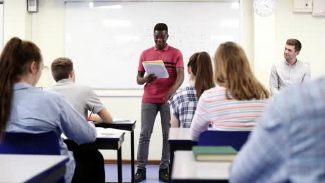 Estudiante-masculino-dando-presentación-a-la-clase-de-la-High-School-secundaria-en-ciencia