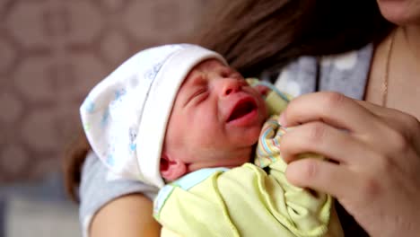 Sweet-crying-newborn-baby-at-mom-on-hands.-Newborn-crying-baby.-Children-cry.