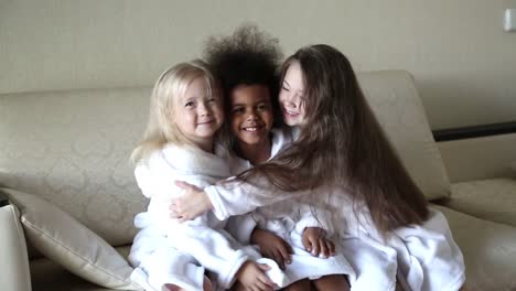 Three-girls-of-different-nationalities-are-sitting-on-the-couch.