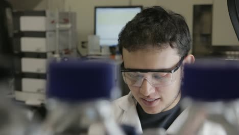 A-handheld-shot-of-a-researcher-pipetting-samples-to-erlenmeyerl-in-a-genetic-laboratory-at-university