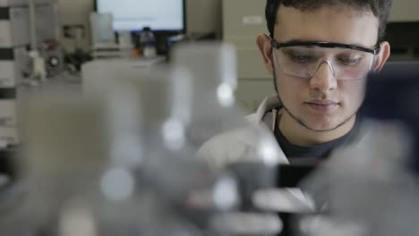 A-handheld-shot-of-a-researcher-pipetting-samples-to-erlenmeyerl-in-a-genetic-laboratory-at-university