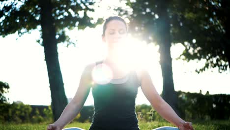 Beautiful-slender-woman-in-lotus-position-practicing-yoga-in-the-park