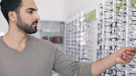 Tienda-de-gafas.-Hombre-tratando-de-gafas-en-la-tienda-de-óptica