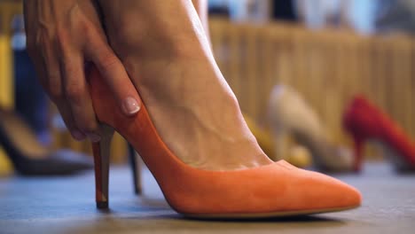 young-woman-trying-heeled-shoes-at-store