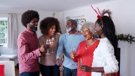 Porträt-von-Eltern-mit-Erwachsenen-Nachkommen-einen-Toast-mit-Champagner-zu-machen,-wie-sie-Weihnachten-feiern