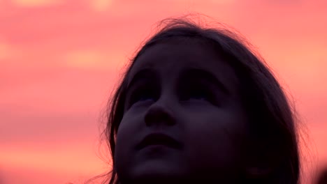 Niño-mirando-el-cielo-en-la-naturaleza.-Niña-rezando-mirando-hacia-arriba-en-el-cielo-púrpura-con-esperanza,-Close-up.