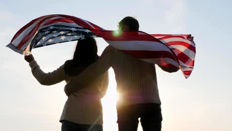 Parte-posterior-vista-familia-patriótica-con-una-bandera-grande-de-América