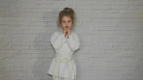 girl,--child-in-a-kimono-on-karate-training-works-out-blows-and-greeting