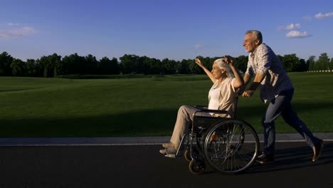 Hombre-edad-corriendo-empujando-esposa-en-silla-de-ruedas