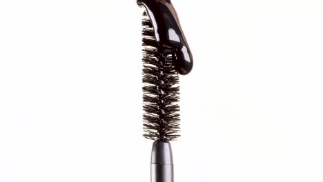 drops-of-black-mascara-fall-on-the-brush-on-a-white-background