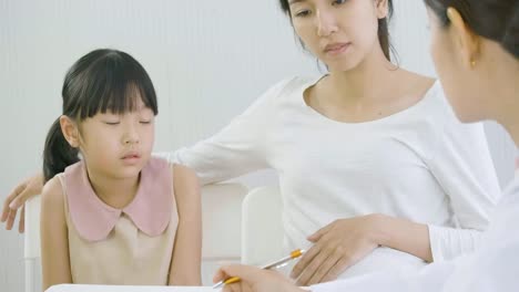 Mujer-embarazada-y-niño-visitando-el-consultorio-del-médico.